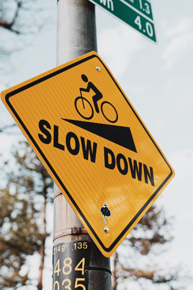 Gelbes Straßenschild mit der Aufschrift "Slow down".