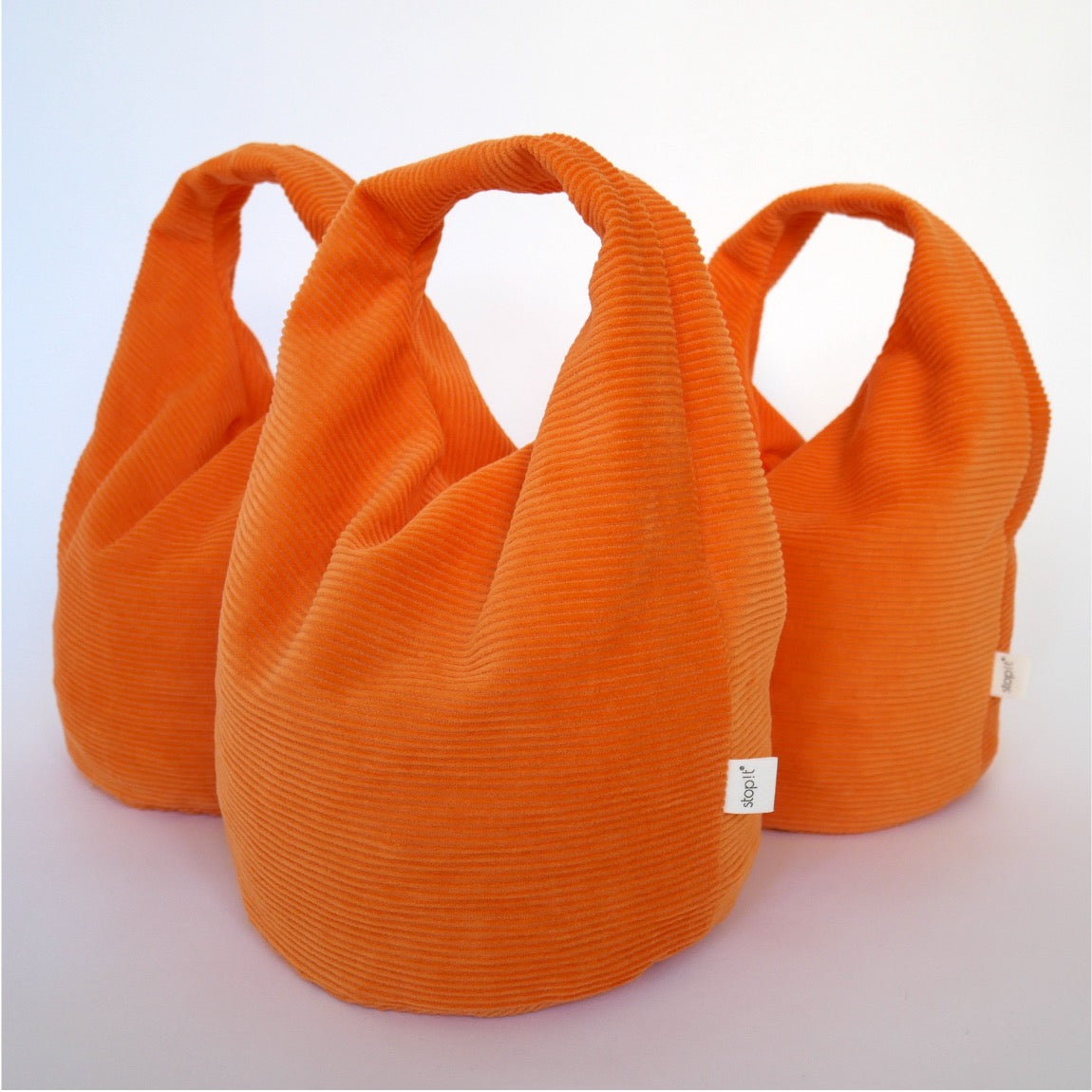 3 Türstopper Carrot Cordulino mit Baumwoll-Cordbezug von stop!t dekorativ schräg hintereinander.