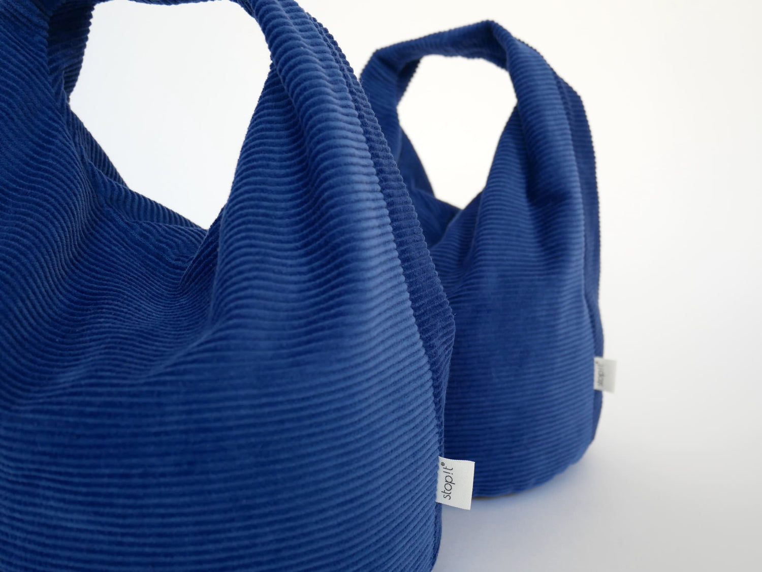 2 Türstopper Cobalt Cordulino mit Baumwoll-Cordbezug von stop!t dekorativ in Nahaufnahme schräg hintereinander.
