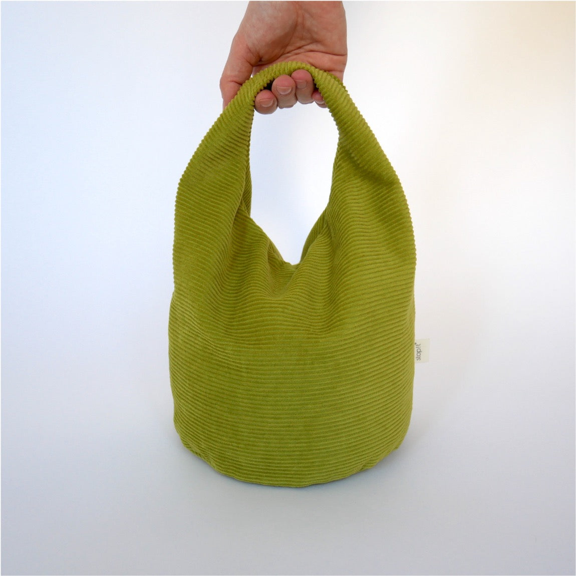 Türstopper Cricket Cordulino mit Baumwoll-Cordbezug von stop!t Produktfoto mit menschlicher Hand am Tragegriff.