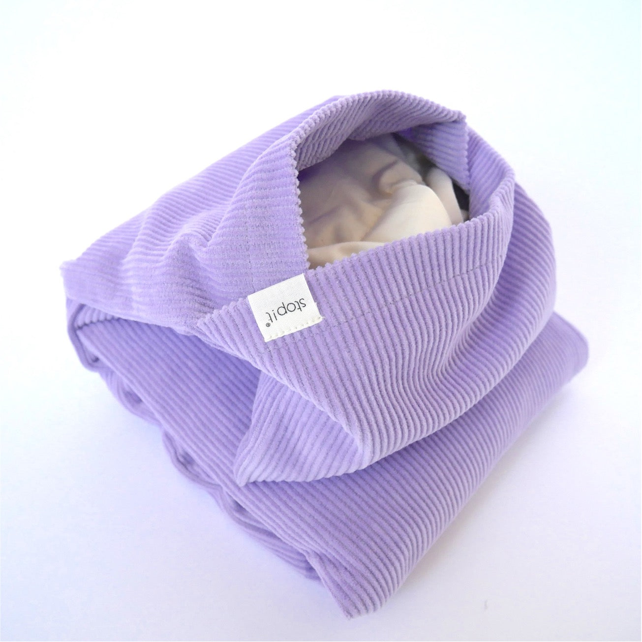 Wärmekissen Hot Cordie Lilac Tree liegt in Nahaufnahme im Bild. Das Produktfoto zeigt die Öffnung des Cord-Außenbezuges und das sich darin befindende Inlay.