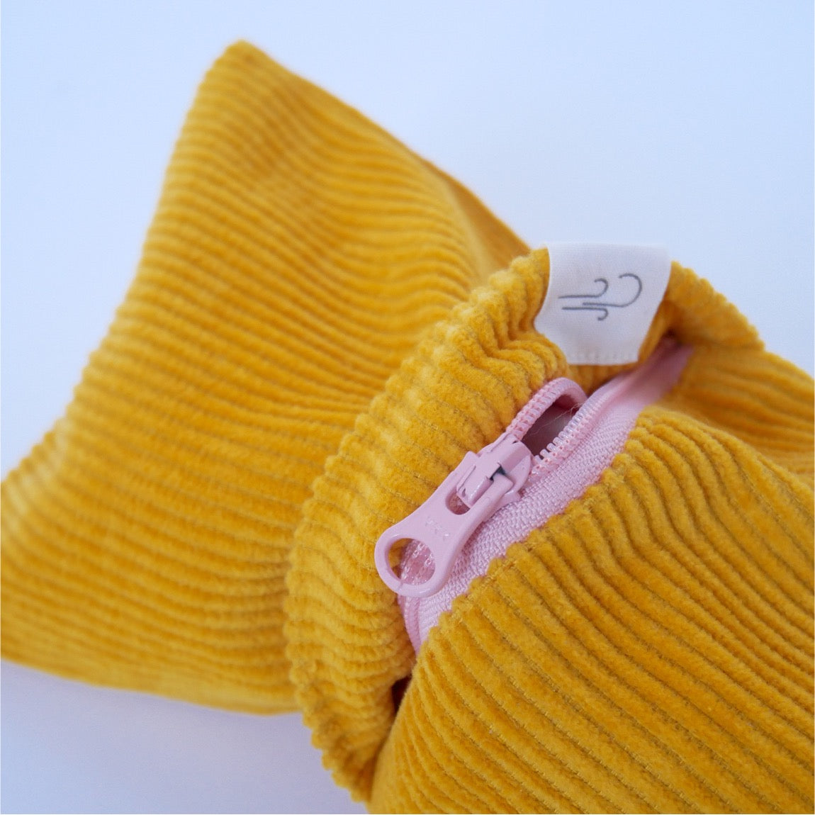 stopit Zugluftstopper Mustard Cordula Produktfoto. Nahaufnahme von dem Reißverschluss, der Zugang zum Inlett verschafft.